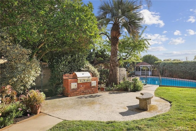 view of patio with a fenced in pool, area for grilling, a fenced backyard, and a grill