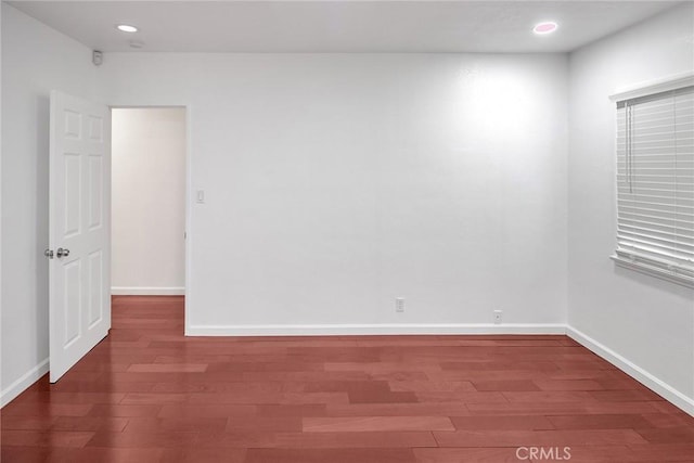 empty room featuring recessed lighting, wood finished floors, and baseboards