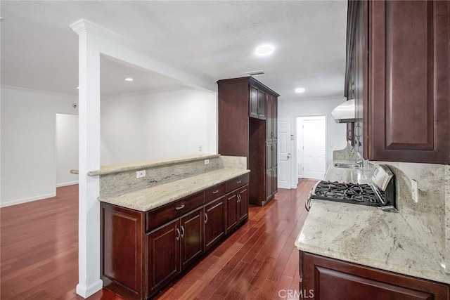 kitchen featuring dark brown cabinets, crown molding, light stone countertops, range hood, and dark wood-style flooring