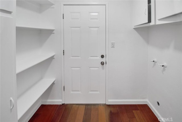 washroom with baseboards and dark wood-style floors