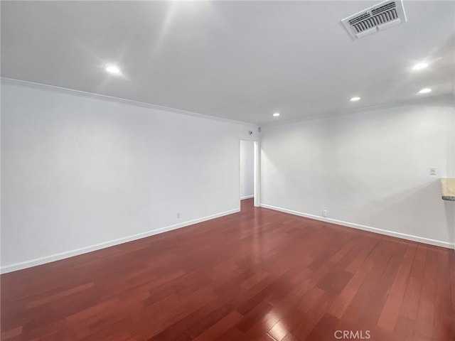 spare room with dark wood-style floors, visible vents, recessed lighting, and baseboards