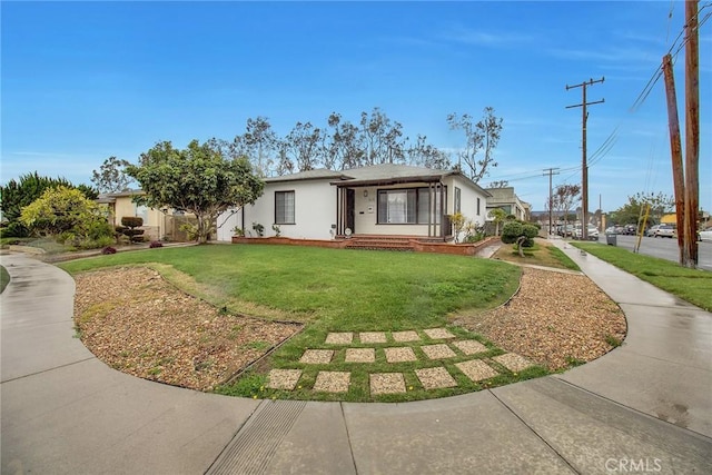 view of front of property featuring stucco siding and a front yard