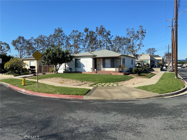 single story home with stucco siding and a front yard