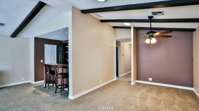 spare room featuring lofted ceiling with beams, baseboards, and carpet floors