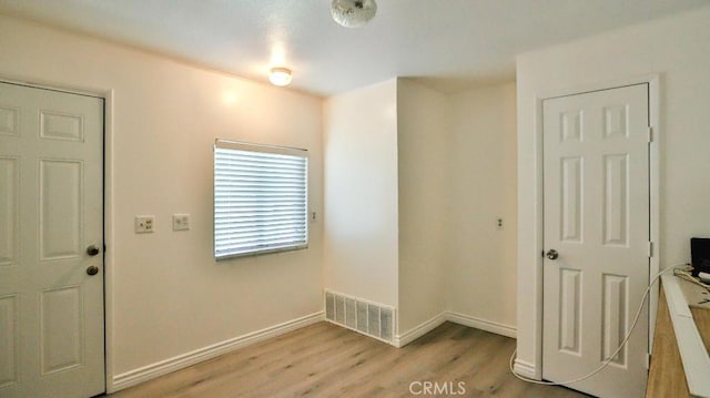 entrance foyer with light wood-style floors, visible vents, and baseboards