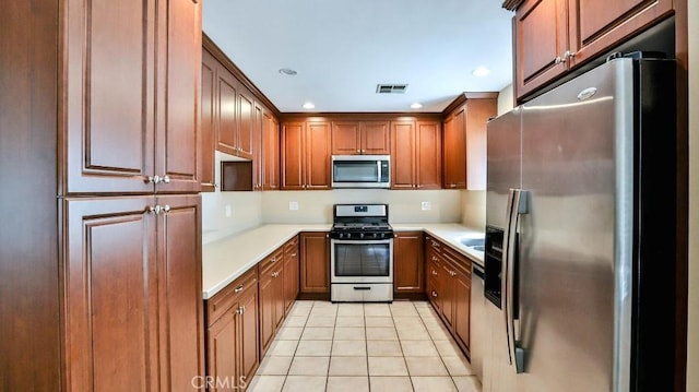 kitchen featuring light countertops, light tile patterned floors, visible vents, and stainless steel appliances