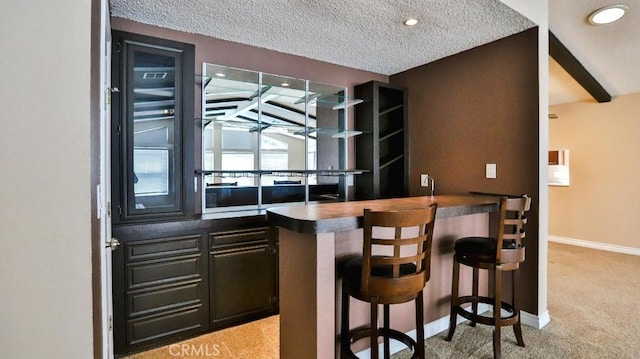 bar with light carpet, a textured ceiling, recessed lighting, wet bar, and baseboards