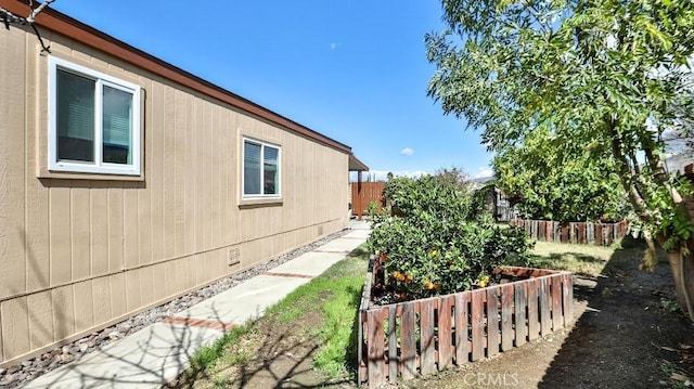 view of home's exterior with a garden, fence, and crawl space