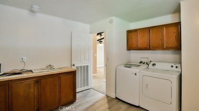 laundry area with washing machine and clothes dryer, visible vents, cabinet space, and light wood-style floors