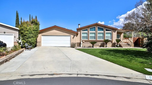 mid-century inspired home featuring a front yard, concrete driveway, and a garage