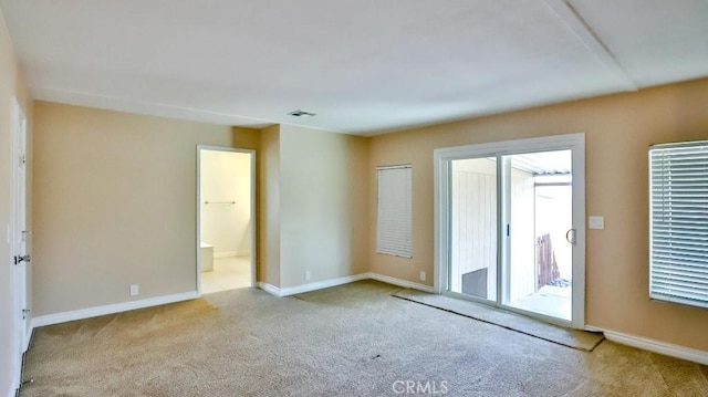 carpeted empty room with visible vents and baseboards