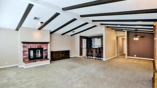 unfurnished living room featuring a ceiling fan, lofted ceiling with beams, carpet flooring, baseboards, and a brick fireplace