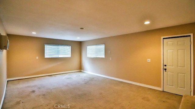 empty room featuring recessed lighting, baseboards, and light carpet