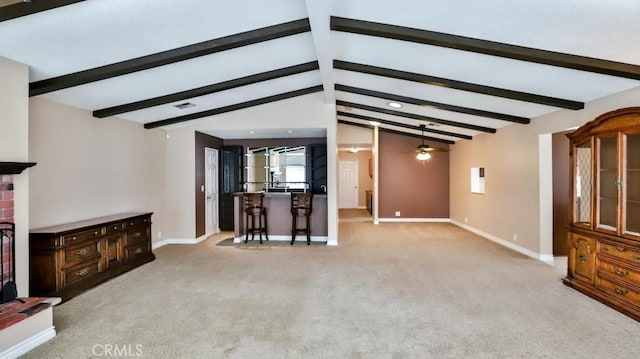 unfurnished living room with carpet, lofted ceiling with beams, a fireplace, and baseboards