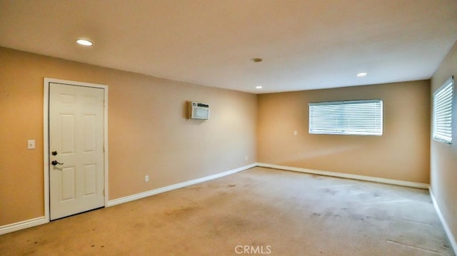 spare room featuring recessed lighting, carpet, baseboards, and a wall unit AC