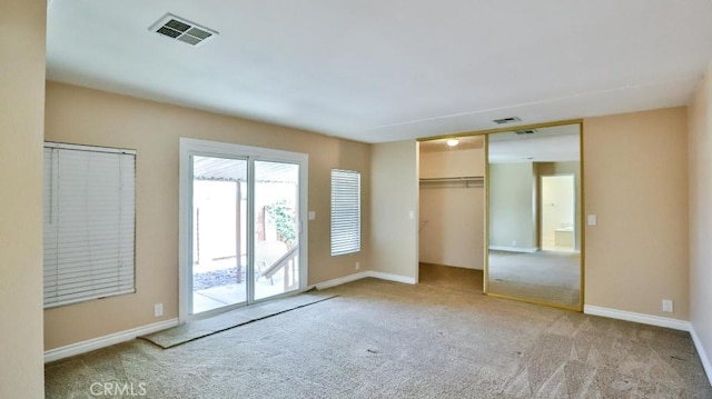 unfurnished bedroom with visible vents, baseboards, carpet, a closet, and access to outside