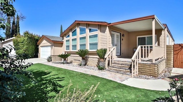 view of front of home featuring a garage, driveway, a front yard, and fence