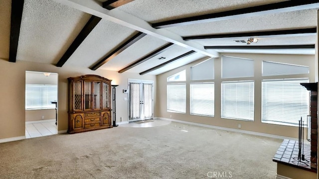 interior space featuring baseboards, a textured ceiling, lofted ceiling with beams, and carpet