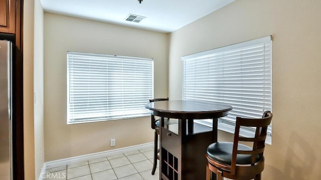 dining area with light tile patterned floors, visible vents, and baseboards