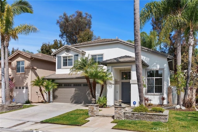 view of front facade with a tile roof, stucco siding, driveway, and an attached garage