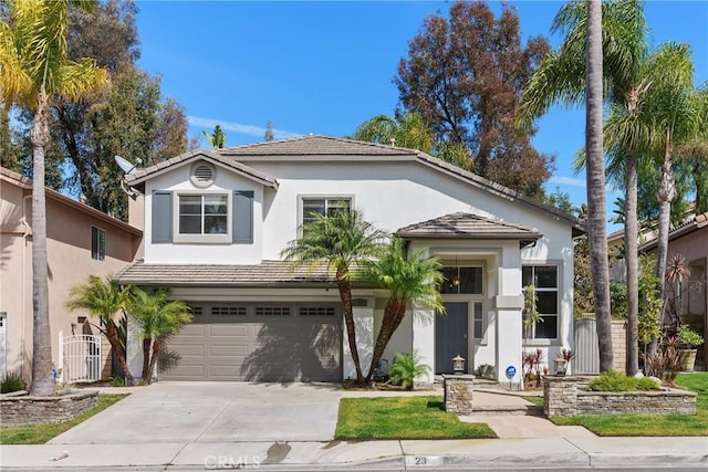 view of front facade with stucco siding, fence, concrete driveway, an attached garage, and a tiled roof