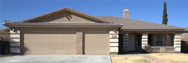 view of front of house with a tiled roof, an attached garage, and driveway