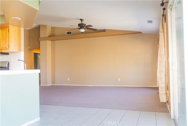 unfurnished room with light carpet, ceiling fan, lofted ceiling, baseboards, and light tile patterned floors