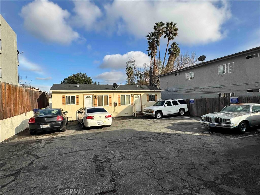 view of front of property featuring uncovered parking and fence