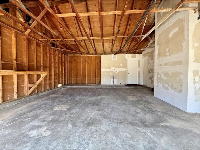 misc room with unfinished concrete floors and a garage