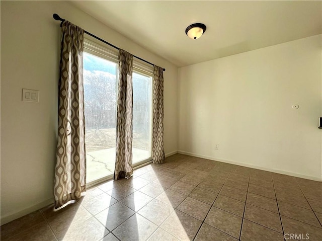 unfurnished room featuring tile patterned flooring and baseboards