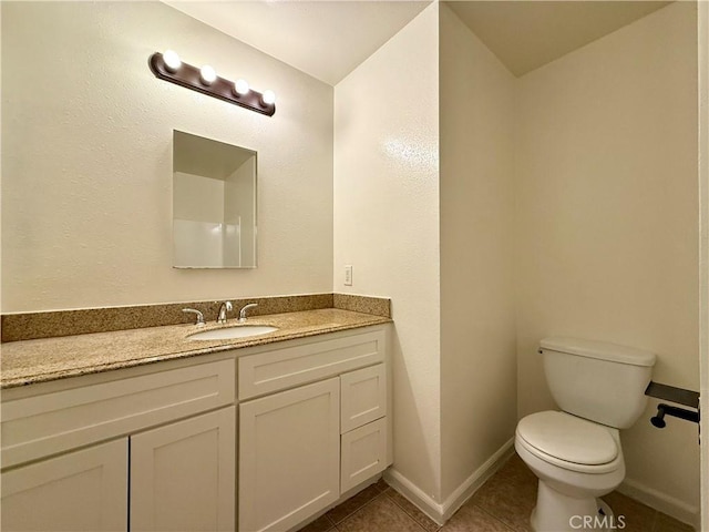 bathroom featuring tile patterned flooring, toilet, vanity, and baseboards