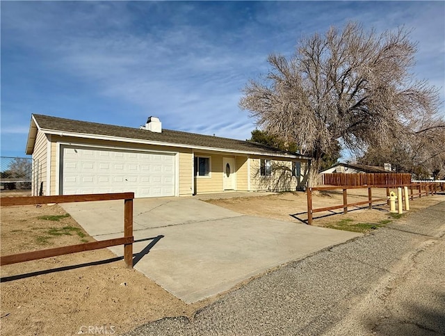 ranch-style house featuring fence, a garage, and driveway