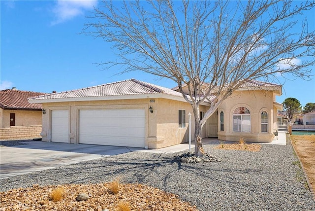 view of front facade with stucco siding, driveway, and an attached garage