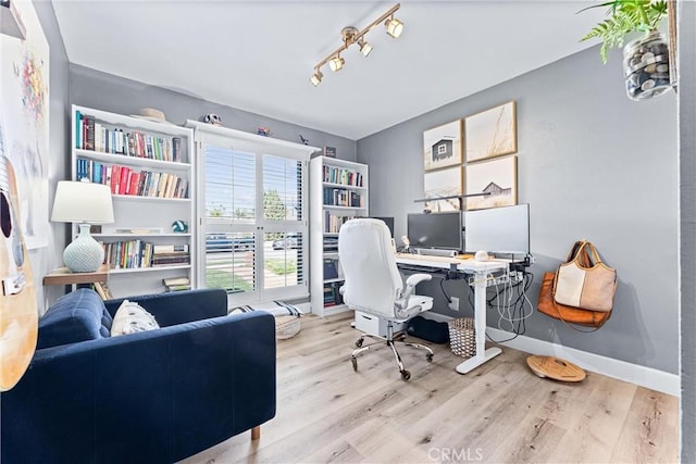 office with baseboards, wood finished floors, and rail lighting