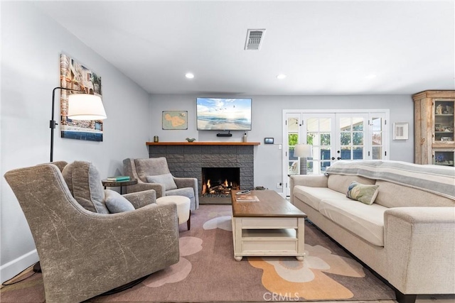 living area with visible vents, recessed lighting, french doors, a brick fireplace, and carpet flooring