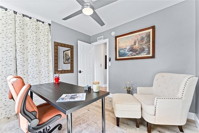 office space featuring visible vents, baseboards, ceiling fan, and wood finished floors