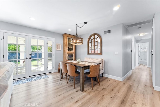 dining room with visible vents, french doors, light wood-type flooring, and baseboards