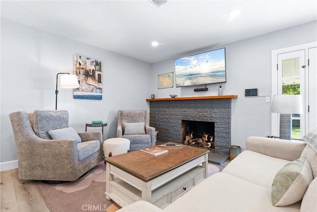 living room featuring wood finished floors, recessed lighting, a fireplace, and baseboards