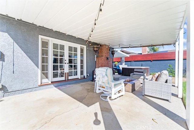 view of patio / terrace featuring french doors and an outdoor living space with a fire pit