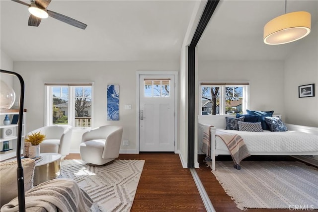 bedroom featuring a ceiling fan, multiple windows, dark wood-style floors, and baseboards