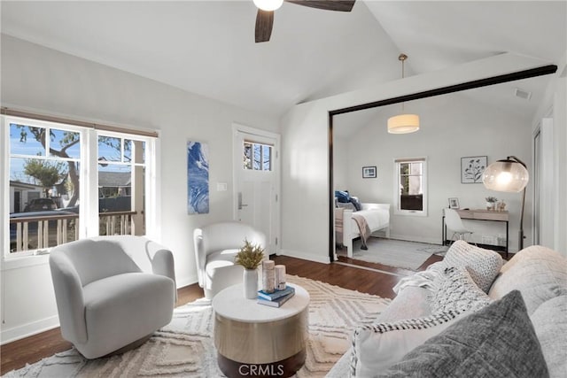 living area featuring visible vents, lofted ceiling, wood finished floors, baseboards, and ceiling fan