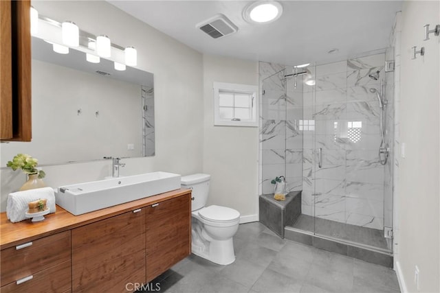 bathroom featuring a marble finish shower, visible vents, toilet, and vanity