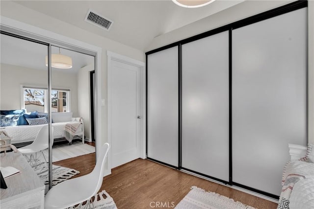 bedroom featuring visible vents and wood finished floors