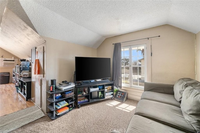 carpeted living area featuring a textured ceiling, an AC wall unit, and lofted ceiling