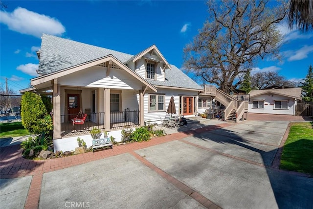 bungalow-style house featuring a porch, french doors, and a shingled roof