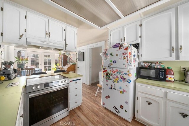 kitchen with stainless steel range with electric stovetop, under cabinet range hood, freestanding refrigerator, black microwave, and light countertops