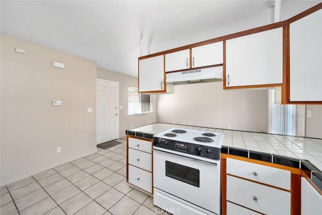 kitchen with tile counters, white cabinets, electric stove, and under cabinet range hood