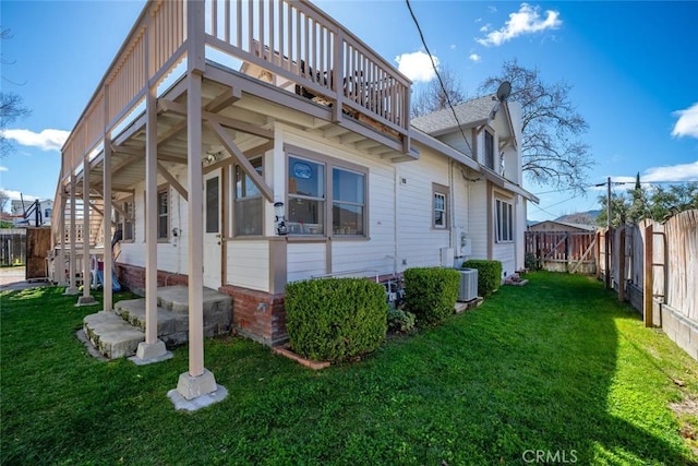 view of side of property with a fenced backyard, central air condition unit, stairs, and a yard