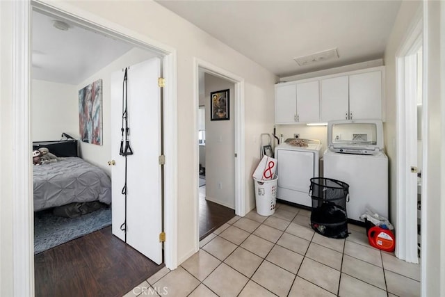 washroom featuring cabinet space, light wood-style flooring, and separate washer and dryer