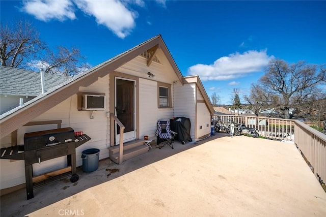 rear view of house with a patio, an AC wall unit, and entry steps